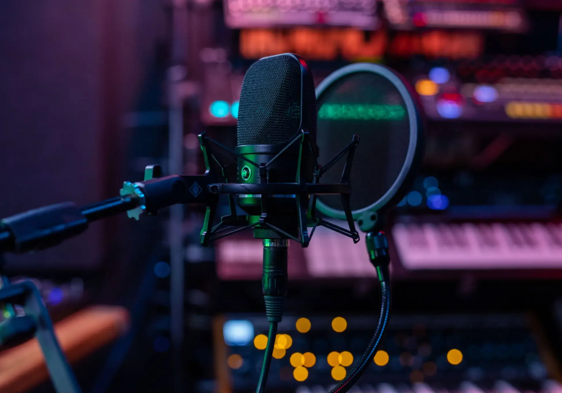 Professional studio microphone setup with pop filter and colorful blurred background.