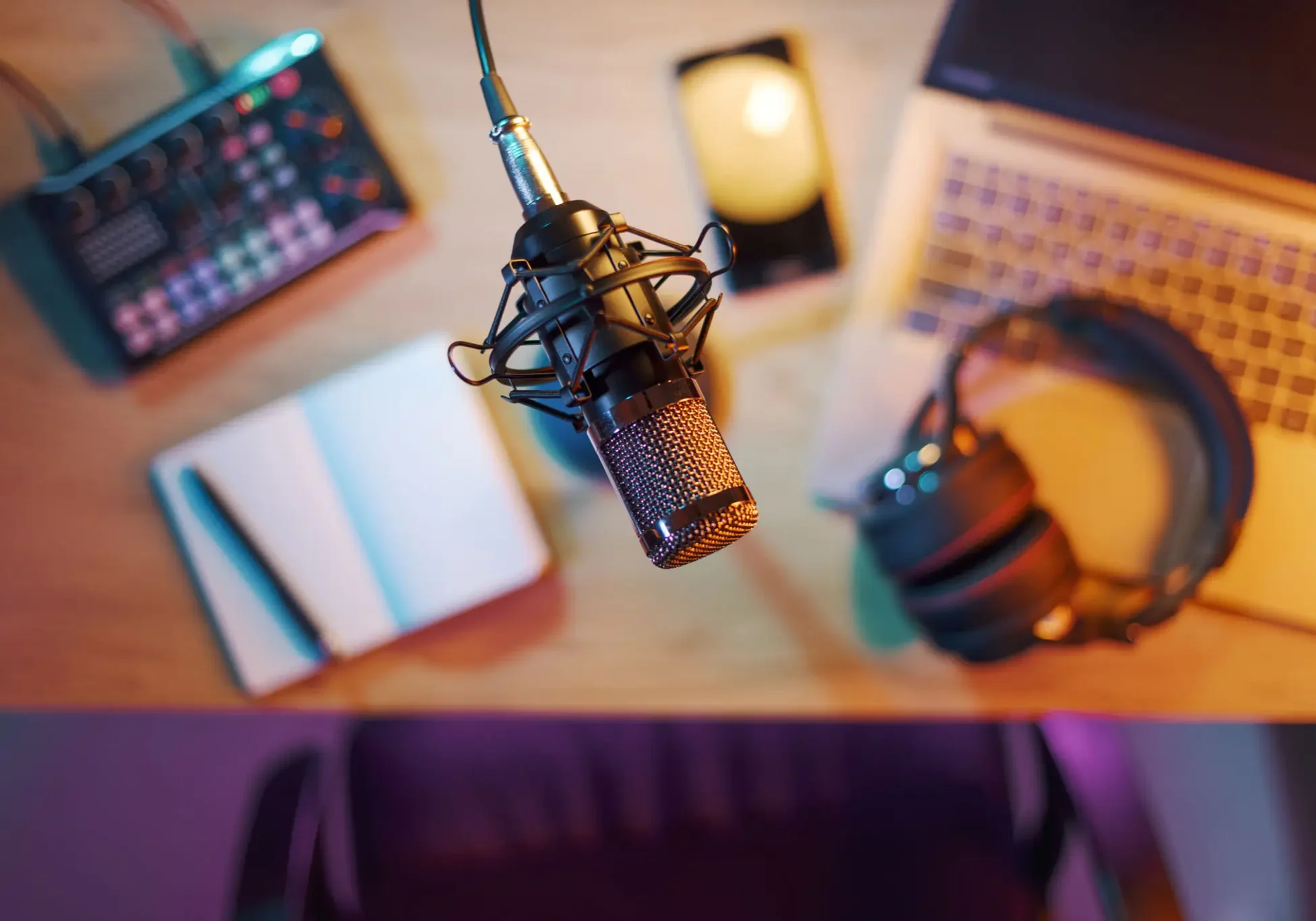 Professional podcast microphone setup with headphones and notebook.